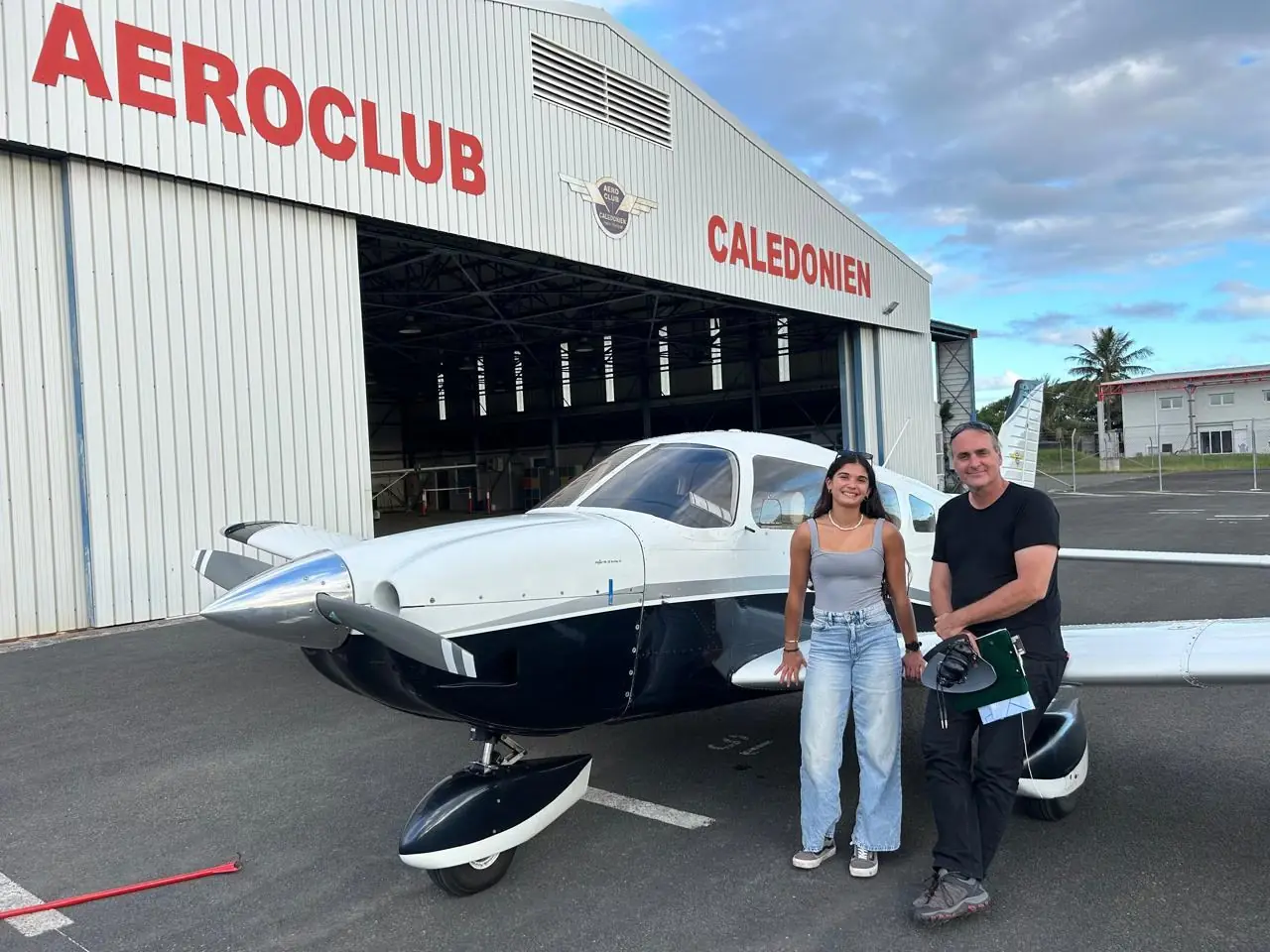 Piper PA-28 F-ONCV du club devant le hangar Aéroclub Calédonien, avec un instructeur et une élève pilote